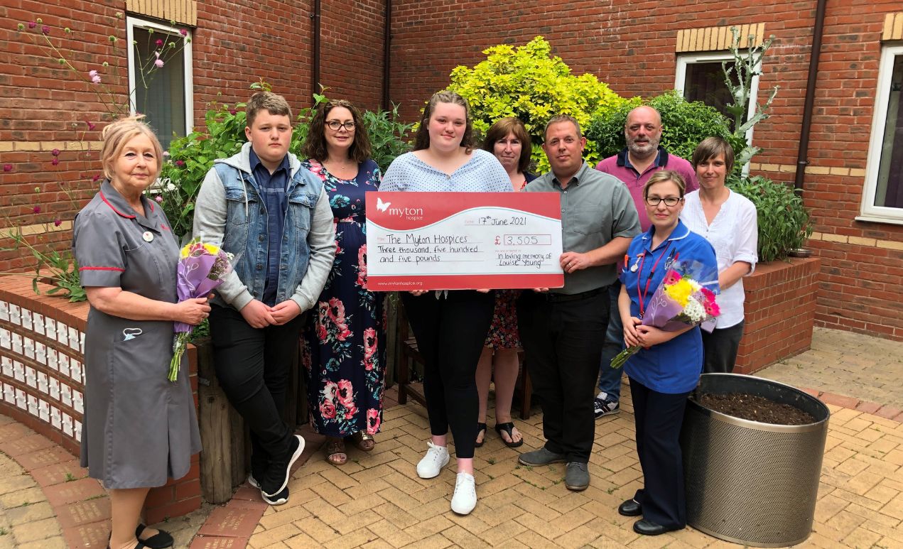 Blog Header (6) Jess with family and nurses with a donation to Myton