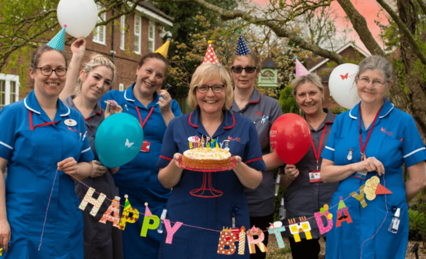 Myton nurses with birthday banner, cake and balloons