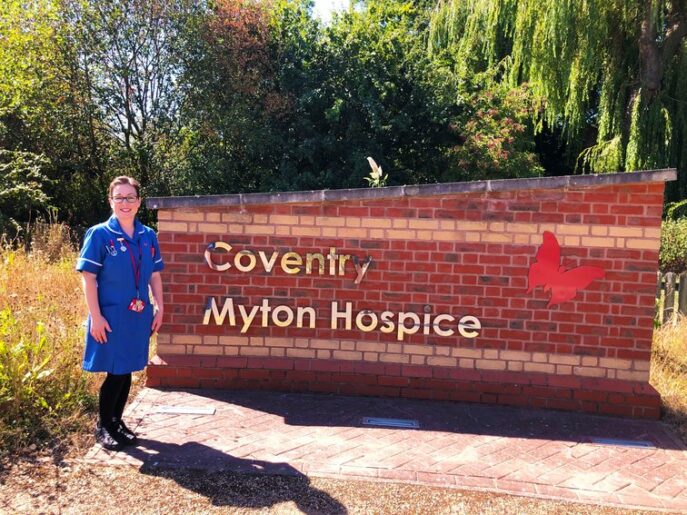 Lizzy Jenkins in front of Coventry Myton Hospice sign