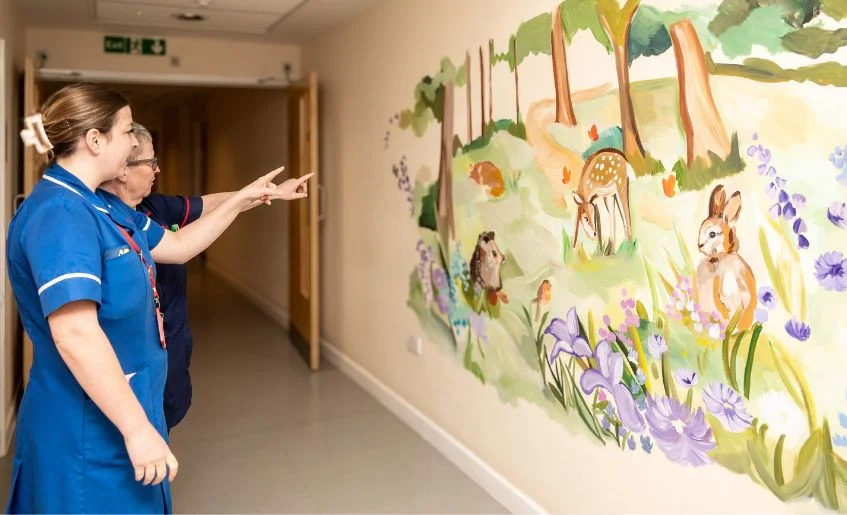The Myton Hospices - Nurses with the mural at Coventry Myton Hospice